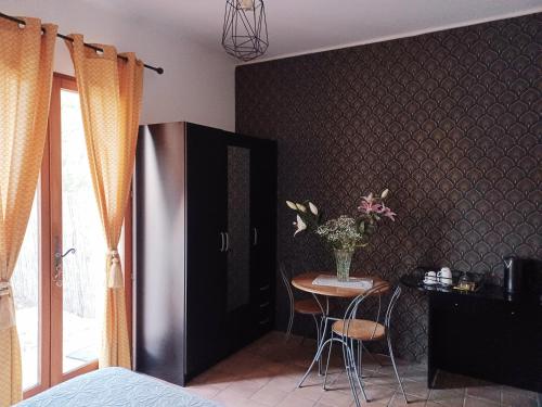 una stanza con un tavolo e un vaso di fiori su un muro di Suite avec jardin entre Aix en Provence, Luberon et Verdon a Peyrolles-en-Provence