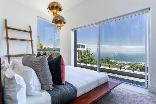 a bedroom with a bed and a large window at The View CampsBay in Cape Town