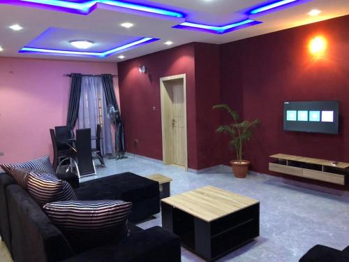 a living room with a couch and a tv at Montrose Gardens in Lagos