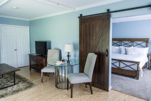 um quarto com uma cama, uma mesa de vidro e uma porta em Marriott Ranch Bed and Breakfast em Hume
