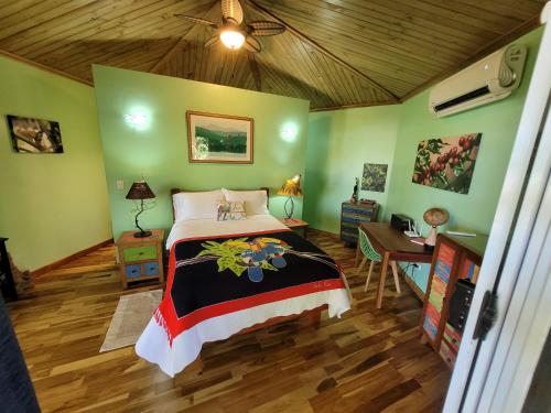 a bedroom with a bed and a desk in a room at Treehouse La Hierba, Pavones in Pavones