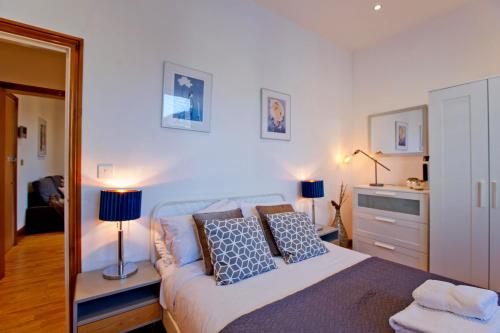 ein Schlafzimmer mit einem Bett mit Kissen und einem Spiegel in der Unterkunft Calabria 3 - Spacious apartment in London