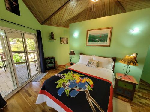 una camera con un letto in una stanza con pareti verdi di Treehouse La Hierba, Pavones a Pavones