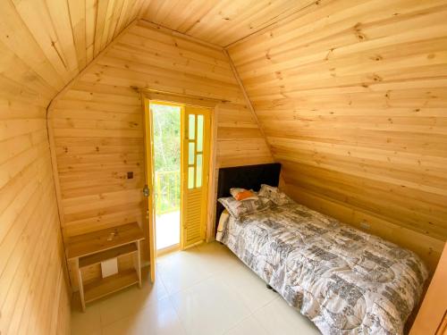 a bedroom in a log cabin with a bed at Cabaña campestre en Chiquinquirá in Saboyá