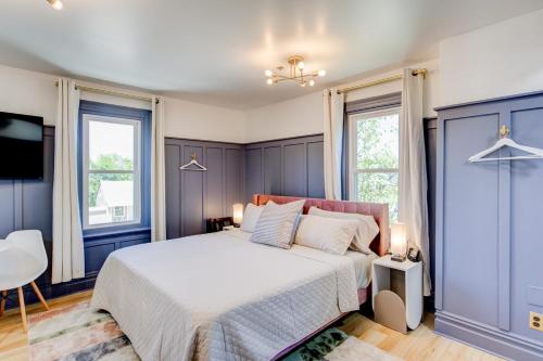 1 dormitorio con 1 cama con paredes y ventanas azules en Suite 11 Historic Art City Inn en Springville