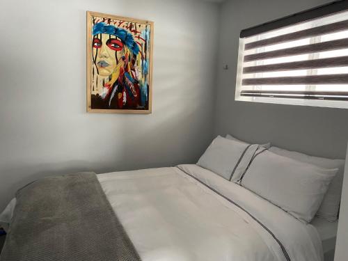 a bedroom with a bed with a painting on the wall at Le Monk ,chalet, motoneige, quad ,nature, randonné pédestre in Montmagny