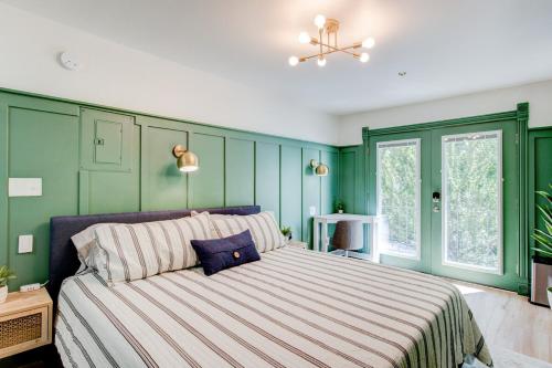 um quarto com paredes verdes e uma cama grande em Suite 9 Historic Art City Inn em Springville