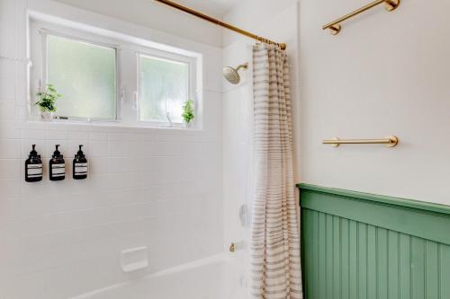 ein Bad mit einem grünen und weißen Duschvorhang in der Unterkunft Suite 9 Historic Art City Inn in Springville
