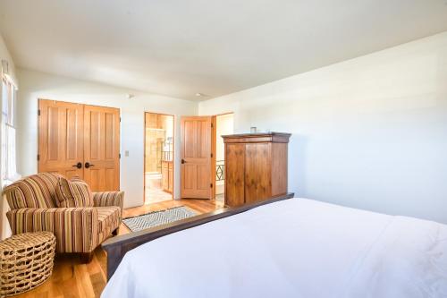 a bedroom with a white bed and a chair at El Corazon #30 in Santa Fe