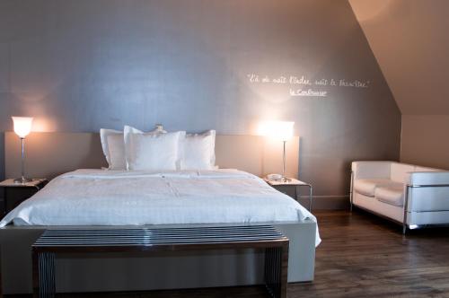 a bedroom with a bed with a quote on the wall at Hotel Recour in Poperinge
