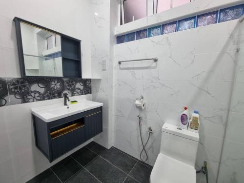 ein Badezimmer mit einem Waschbecken, einem WC und einem Spiegel in der Unterkunft Sweet 3 bedroom home @ Canning Garden, Ipoh in Ipoh