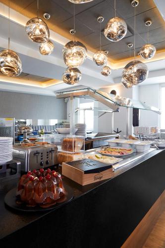 a restaurant kitchen with a counter with food on it at Ejecutivo Express Guadalajara Providencia - Av México in Guadalajara