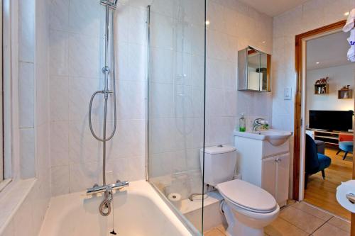 ein Badezimmer mit einer Dusche, einem WC und einer Badewanne in der Unterkunft Convenient 1 bedroom apartment with parking in London