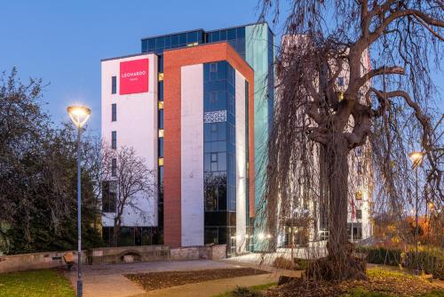 a building with a tree in front of it at Leonardo Hotel Derby in Derby