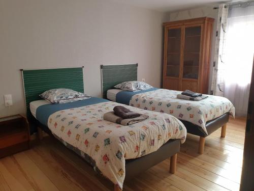 - une chambre avec 2 lits et des serviettes dans l'établissement Au Relais Du Canal à Grand Gabarit, à Nesle
