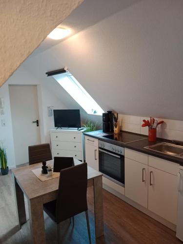 eine Küche mit einem Esstisch und eine Küche mit einem Fenster in der Unterkunft Flensburg Zentrum 10 HH DGR in Flensburg