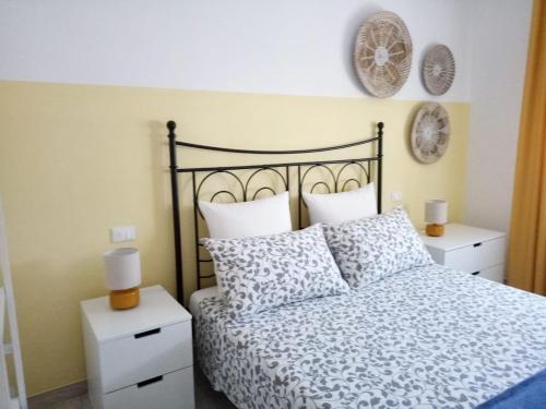 een slaapkamer met een zwart-wit bed en 2 nachtkastjes bij Le Saline Bed & Breakfast in Cervia