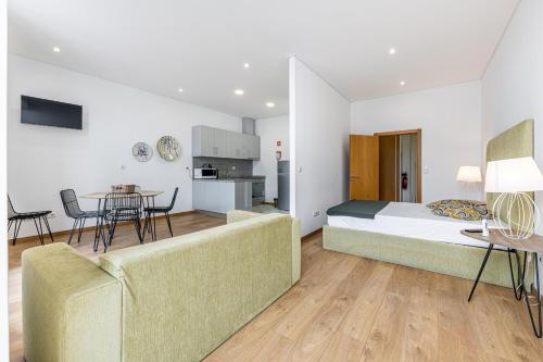 Habitación de hotel con cama, sofá y mesa en Asgard Oporto Downtown Apartments, en Oporto