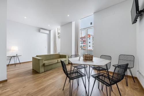 sala de estar con mesa, sillas y sofá en Asgard Oporto Downtown Apartments, en Oporto