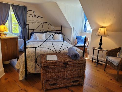 a bedroom with a bed with a wrought iron frame at Om Villégiature in Saint-Laurent-de-l'ile d'Orleans