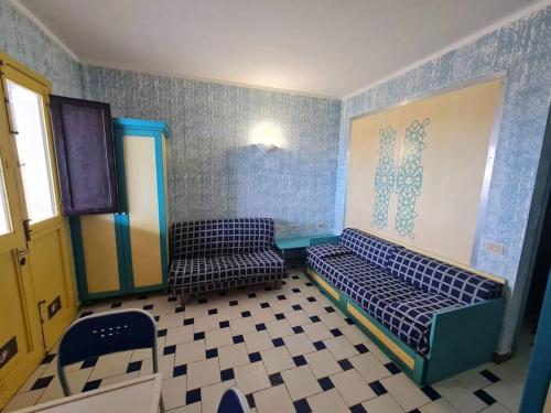 a room with two beds in a room with blue walls at Dammuso Sul mare MDQ Sea in Pantelleria