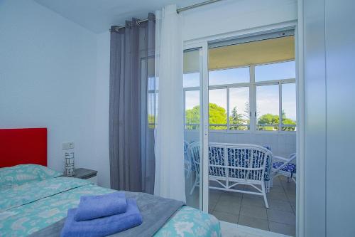 プレヤス・デ・オリフエラにある237 Relax Sol Naciente Alicante Holidayのベッドルーム1室(ベッド1台付)、スライド式ガラスドアが備わります。