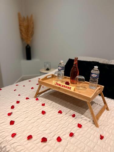 a coffee table on a bed with red hearts on it at Modern SPA - Cosy & Chic - JACCUZI in Brunoy