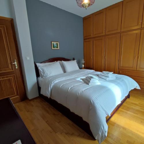 a bedroom with a large white bed with wooden cabinets at Friendly Flat 5 in Edessa