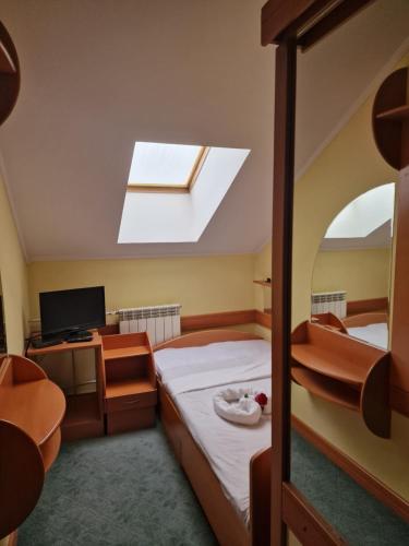 a bedroom with a bed and a skylight at Hotel Lupus in Novi Sad