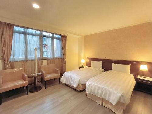 a hotel room with two beds and a window at 文化信然 in Tainan