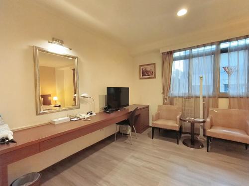 a hotel room with a desk with a television and a mirror at 文化信然 in Tainan