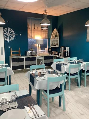 a dining room with blue walls and white tables and chairs at By the Seaside in Blackpool