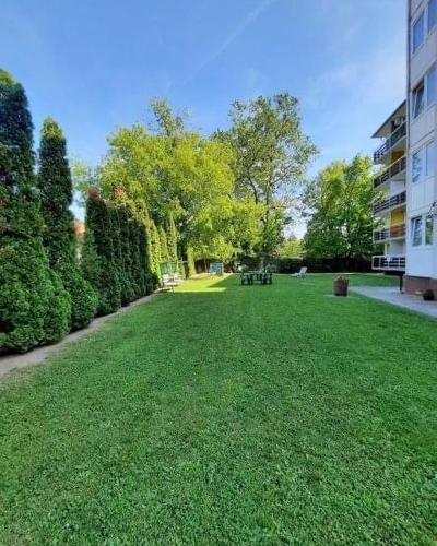 a large yard with green grass and a building at Silver Lodge Ezüstpart Apartman in Siófok