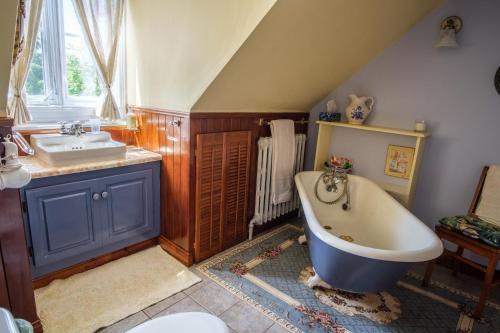 a bathroom with a bath tub and a sink at Om Villégiature in Saint-Laurent-de-l'ile d'Orleans