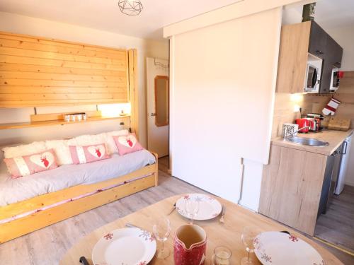 Cette chambre comprend un lit et une table avec des plaques de cuisson. dans l'établissement Appartement cosy dans le centre du village, proche pistes et ESF, avec balcon et équipements complets - FR-1-623-286, aux Gets