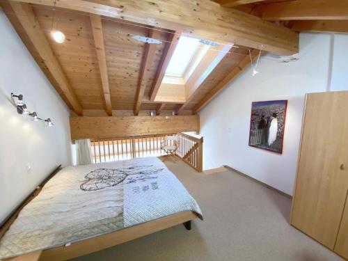um quarto com uma cama grande num quarto com tectos em madeira em Fanzögna 25 em Celerina