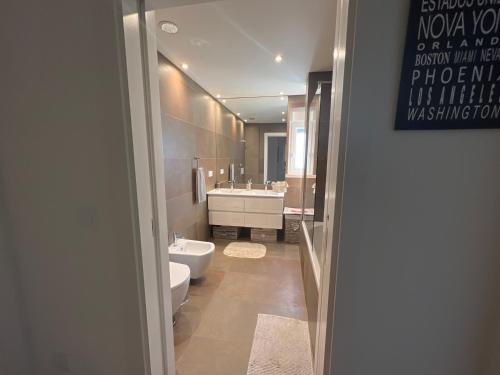 a bathroom with a toilet and a tub and a sink at Modern Double Room with Private Balcony in Montijo