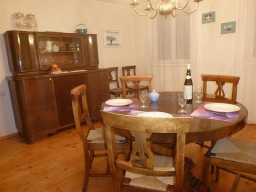 uma sala de jantar com uma mesa com cadeiras e uma garrafa de vinho em Ferienhaus Buschle em Tettnang