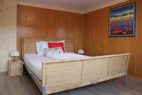 1 dormitorio con 1 cama grande y pared de madera en Gast- & Ferienhaus Frohheim en Sankt Peterzell