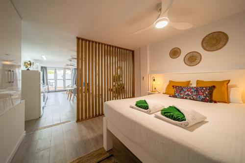 1 dormitorio con 1 cama blanca grande con almohadas verdes en Apartamento Alisios Beach Puerto del Carmen, en Puerto del Carmen