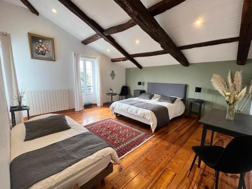 duża sypialnia z 2 łóżkami i stołem w obiekcie maison Laratger w mieście Narrosse