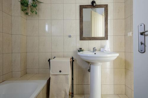 a bathroom with a sink and a mirror and a tub at Villa Alysso in Megála Khoráfia