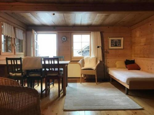 a living room with a bed and a table and chairs at Chalet Flädermuus in Frutigen