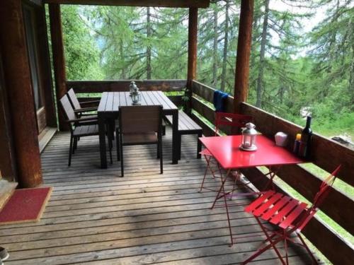 een veranda van een hut met een tafel en stoelen bij Haus Pfahl in Bellwald