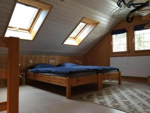a bedroom with a bed in a room with skylights at Brandholz in Ebnat