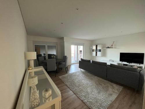 a living room with a couch and a television at Modern Double Room with Private Balcony in Montijo