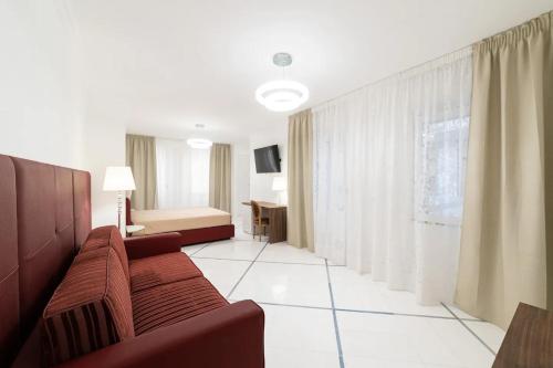 un soggiorno con divano e una camera da letto di Apartments Hotel Real Suite Napoli Chiaia Mergellina a Napoli