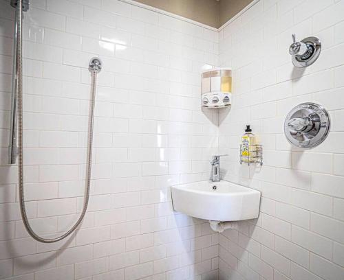 een witte badkamer met een wastafel en een douche bij 1786 Farm Cottage Honeymoon Suite Renovated 2022 in Chester