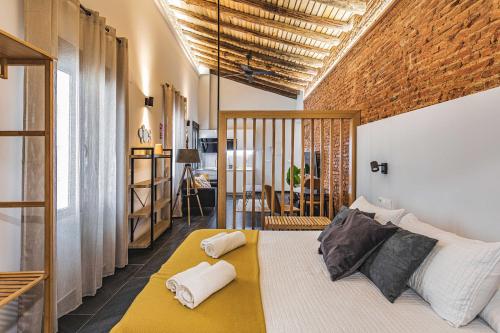 a bedroom with a large bed with pillows on it at Apartamentos Cáceres Central Suites "Torres de Cáceres" in Cáceres