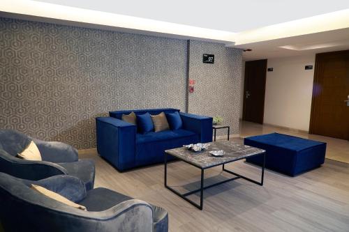 a living room with blue couches and a table at Ejecutivo Express Guadalajara Providencia - Av México in Guadalajara